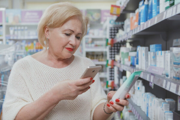 older woman scanning lotion bottle